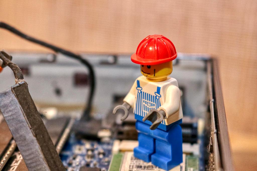 Stack of open books with laptop on desk symbolizing IT resources